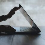 Closeup image of a hand close or open a laptop computer, getting ready for work