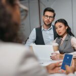 multiethnic businesspeople working together with tablet and smartphone with facebook appliance