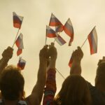 Russian people's hands with flags.