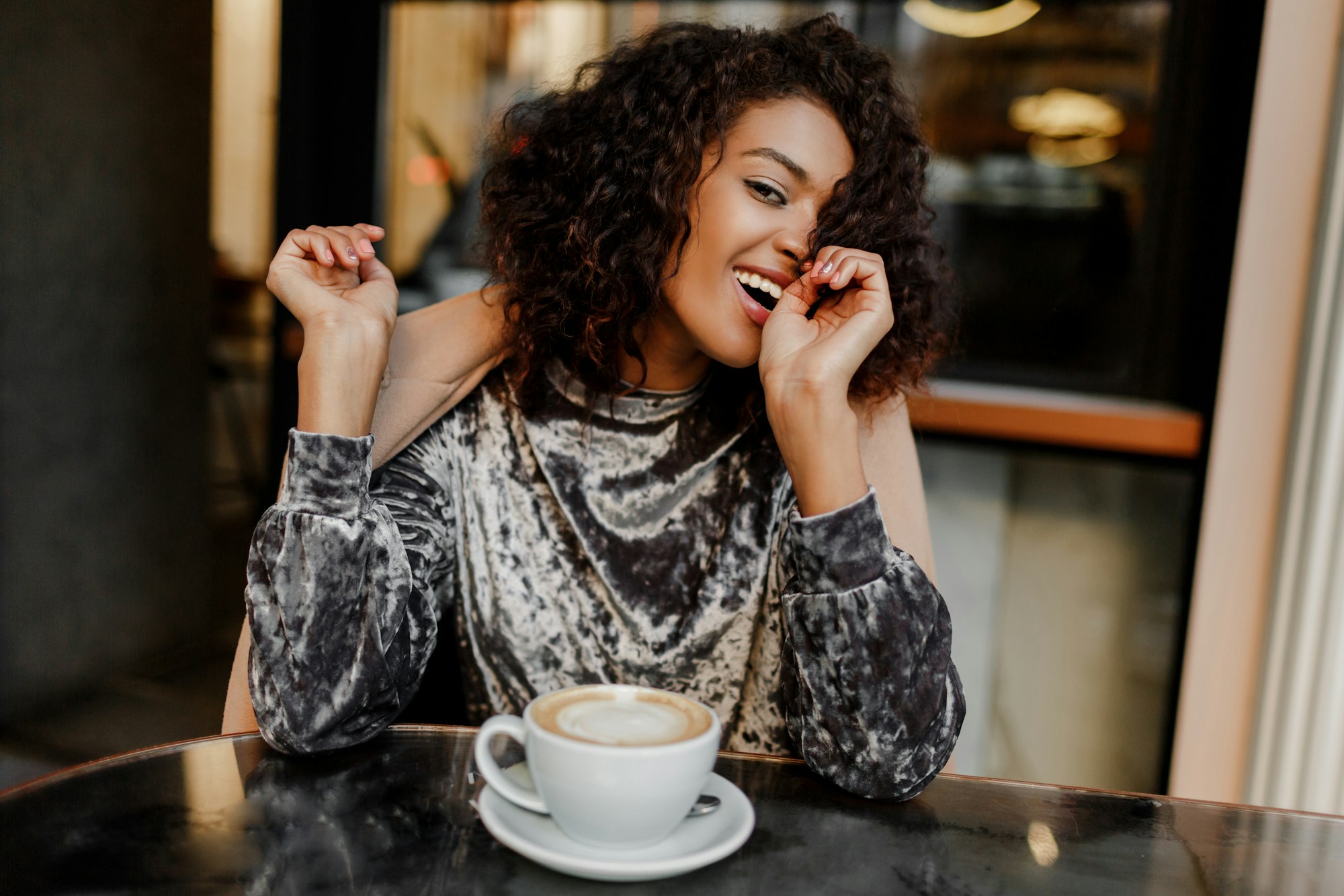 Portrait of happy carefree black woman enjoying coffee break in Paris.