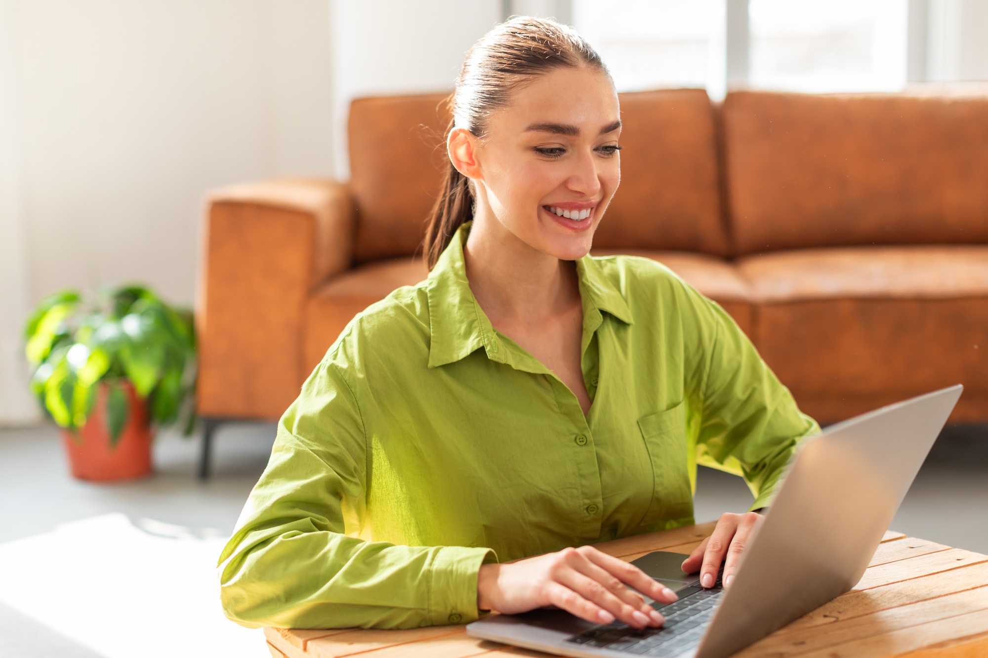 Woman Sitting at Table Using Laptop Computer