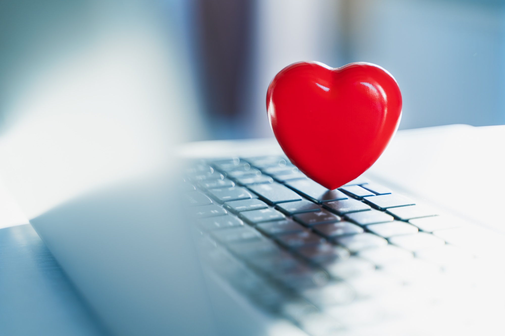 Big red heart on laptop keyboard. Valentine's day holiday concept. Online love, remote communication