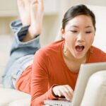 Surprised woman using laptop