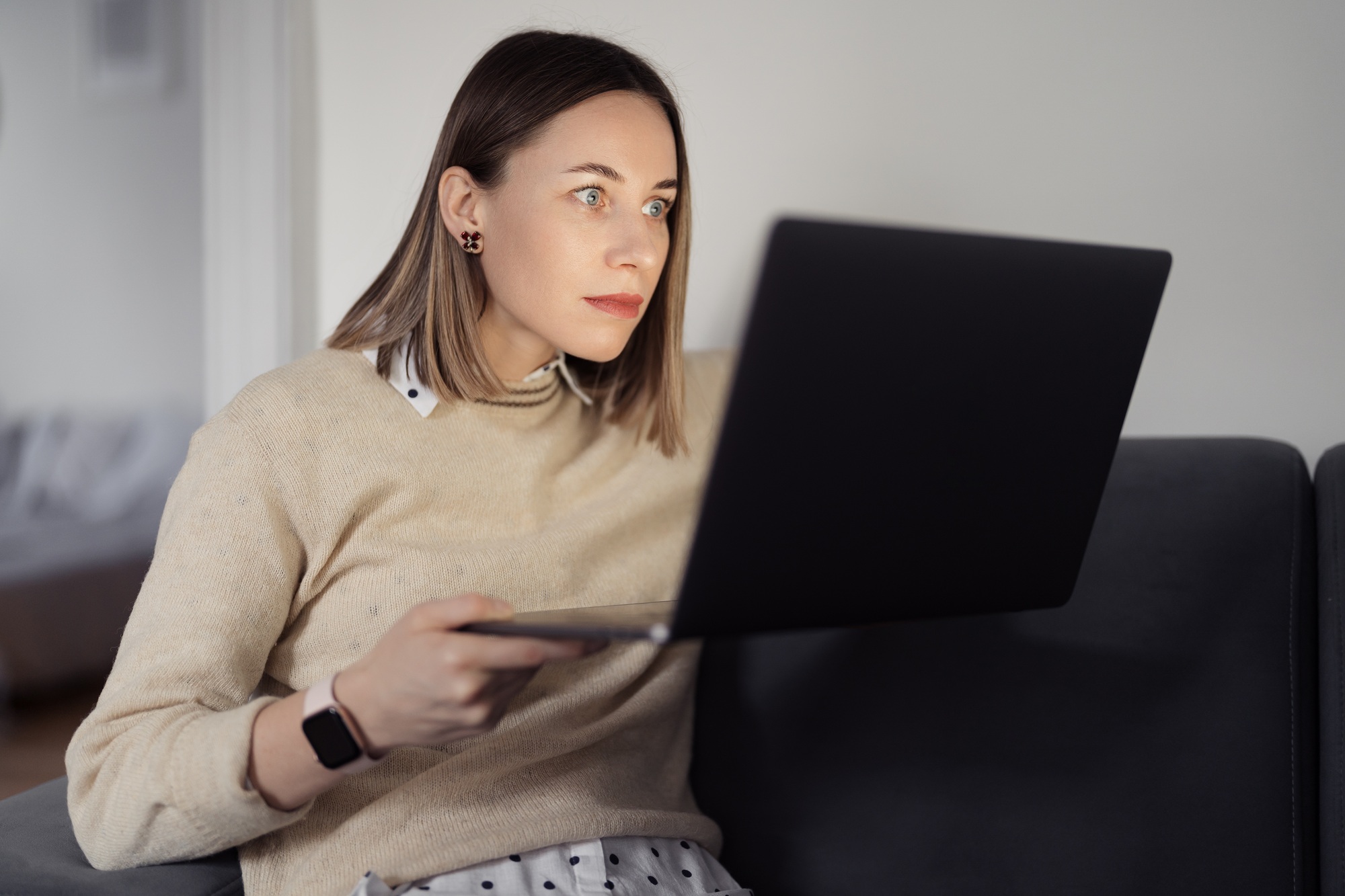 Woman looking surprised to the laptop